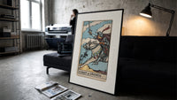 Armored knight riding horse with sword print in a slim black frame leaning on a dark sofa in a concrete print studio
