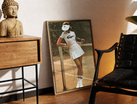 Brass-framed Lacoste vintage tennis print leaning in a warm styled corner by a sculpture