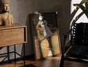 Walnut-framed Lacoste vintage tennis print leaning against a sunlit rustic brick wall