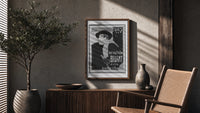 Man in hat and scarf poster framed above a fluted sideboard beside an olive tree