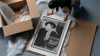 Man in hat and scarf framed print being unpacked from protective bubble wrap and a box