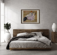 Two reclining women on sofa print in a dark wood frame above a rattan bed on a plaster wall