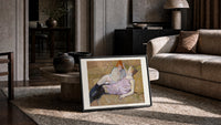 Two reclining women on sofa print in a slim black frame leaning on a travertine coffee table