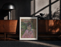 Black-framed Woman in pink dress portrait print on a moody console with designer coffee-table books
