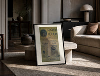 Vintage French soap advertisement with cat print in a black frame leaning on a travertine table in a sunlit lounge