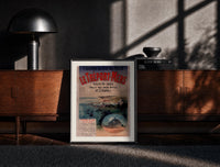 Black-framed coastal seaside town harbour view print on a moody console with designer coffee-table books