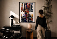 Anime hero collage print in a black frame on a sunlit plaster wall, a woman looking on beside a mushroom lamp