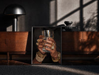 Black-framed Leopard Nails and Gold Rings print on the floor in front of a dark wooden console
