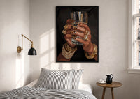 Leopard Nails and Gold Rings print in a black frame above a bed with striped linens, a brass wall lamp and a sunlit window