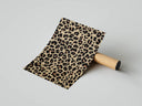 Leopard print pattern in beige and black tones poster resting on a shipping tube