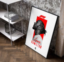 Lewis Hamilton profile portrait poster in a black frame leaning beside a shelf in a raw-plaster loft