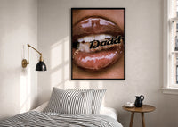 Lips Holding a Daddy Chain print in a black frame above a bed with striped linens, a brass wall lamp and a sunlit window