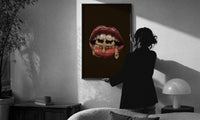 Lips with a Cross and Grillz print in a slim black frame being hung on a sunlit wall in a monochrome room