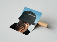 Gently curled Lord's Child Bucket Hat print beside its protective shipping tube