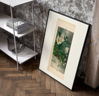 White hellebore flowers with sparrows poster in a black frame leaning beside a shelf in a raw-plaster loft