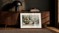 Robin, wrens and tit in snow print in a black frame leaning against a walnut console in lamplight
