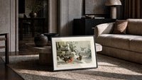 Robin, wrens and tit in snow print in a slim black frame leaning on a travertine coffee table