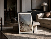 American robin perched on branch print in a black frame leaning on a travertine table in a sunlit lounge