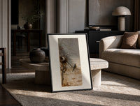 Robin perched on bare branch print in a black frame leaning on a travertine table in a sunlit lounge