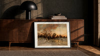 Winter landscape with ice skaters at dusk print in a black frame leaning against a walnut console in lamplight