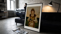Young woman holding roses and book print in a slim black frame leaning on a dark sofa in a concrete print studio