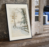 Hunter and dog in snowy landscape print in a black frame leaning beside a vintage door on parquet