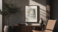Hunter and dog in snowy landscape poster framed above a fluted sideboard beside an olive tree