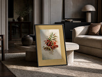 Autumn-tinted leaves branch print in a black frame leaning on a travertine table in a sunlit lounge