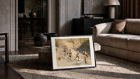 Snowshoers in winter forest print in a black frame leaning on a rug beside a beige sofa