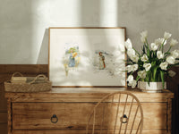 Two young girls holding flowers print in an oak frame on a farmhouse dresser beside white tulips