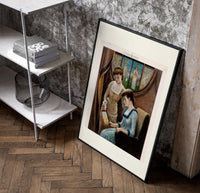 Two Victorian women looking at painting poster in a black frame leaning beside a shelf in a raw-plaster loft