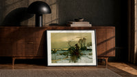 Winter landscape with bare trees print in a black frame leaning against a walnut console in lamplight