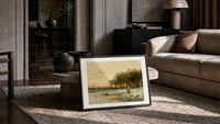 Winter landscape with frozen stream print in a slim black frame leaning on a travertine coffee table