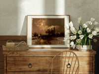 Moonlit winter church landscape print in an oak frame on a farmhouse dresser beside white tulips