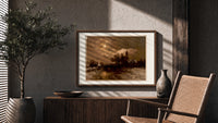 Moonlit winter church landscape print in a wood frame above a fluted sideboard beside an olive tree