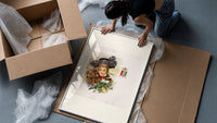 Victorian woman with fur and holly framed print being unpacked from protective bubble wrap and a box