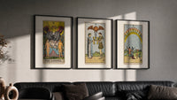 Three Rider-Waite tarot cards triptych in three black frames on a grey wall above a leather sofa