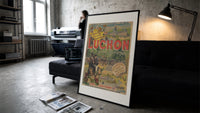 Man on horse at festival print in a slim black frame leaning on a dark sofa in a concrete print studio