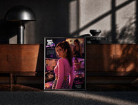 Black-framed Woman in pink top fan art print on a moody console with designer coffee-table books