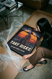 Woman unboxing the Luffy Take Risks Sunset One Piece print from cardboard packaging