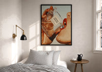 Luxury Fragrance Portrait print in a black frame above a bed with striped linens, a brass wall lamp and a sunlit window
