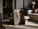 Anime warrior in red armor print in a black frame leaning on a travertine table in a sunlit lounge