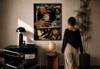 Manicured Hands on a Vinyl Record print in a black frame on a sunlit plaster wall, a woman looking on beside a mushroom lamp
