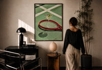 Racket and Martini print in a black frame on a sunlit plaster wall, a woman looking on beside a mushroom lamp