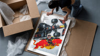 F1 driver celebrating beside race car framed print being unpacked from protective bubble wrap and a box