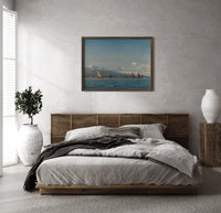 Coastal seascape with sailing boats print in a dark wood frame above a rattan bed on a plaster wall