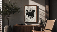 Melting 8 Ball poster framed above a fluted sideboard beside a potted tree