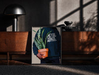 Black-framed Mental Health Matters Potted Plant print on the floor in front of a dark wooden console
