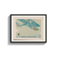 Framed Vintage biplane flying in snow print shown as a wide statement piece on a clean white wall