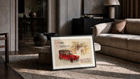 Vintage red touring car in snow print in a slim black frame leaning on a travertine coffee table